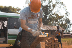 کارگر ساختمانی که چوب را با ابزار برقی برش می‌دهد